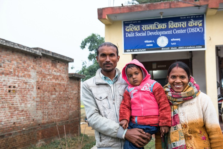 Parshuram Harijan (left), 31 years old, son Sakcham, 4 years old and wife Mayadevi (right) pose for a picture in front of the Dalit Social Development Center. Parshuram works here as a social mobilizer. CARE USA representatives have come to the area to view the progress of the Tipping Point Program, meant to combat child marriage in the districts of Kapilbastu and Rupandehi of Nepal near the Indian border.