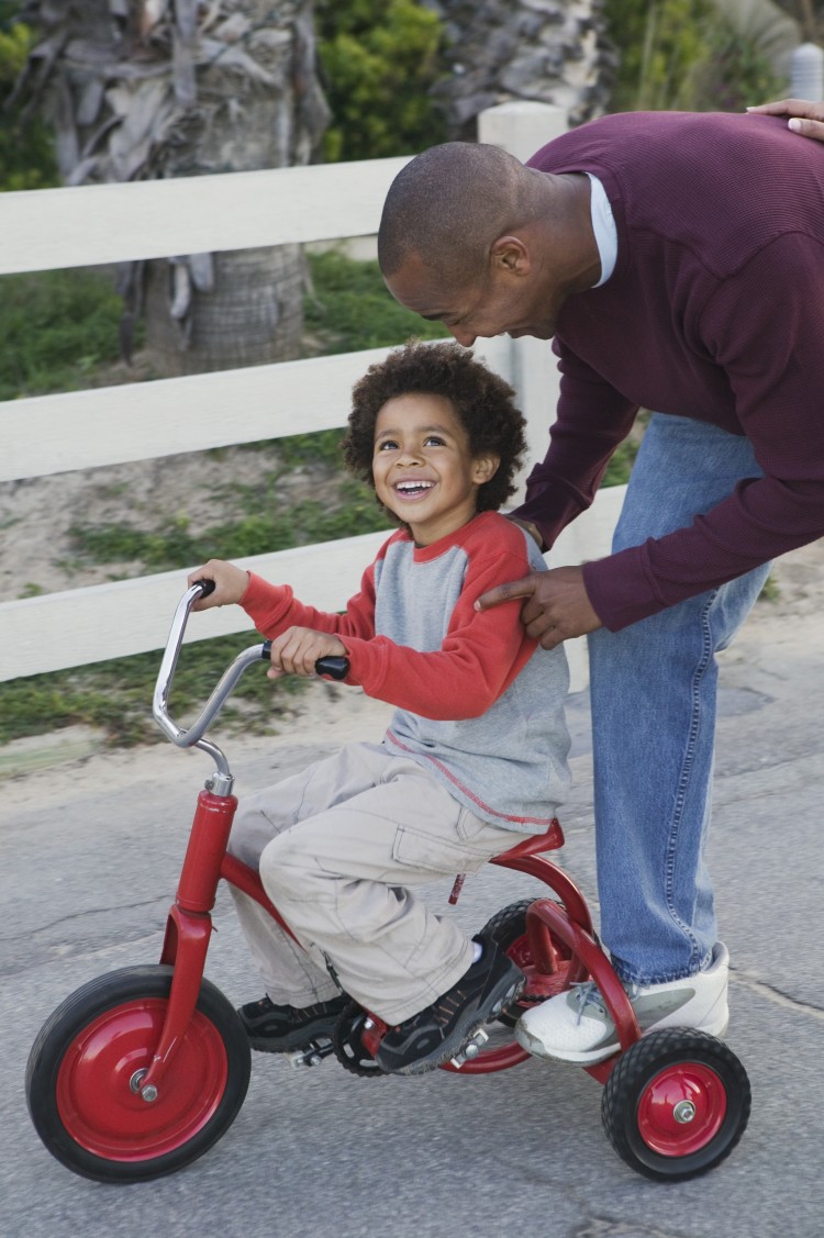 Dad Pushing Son on Tricycle